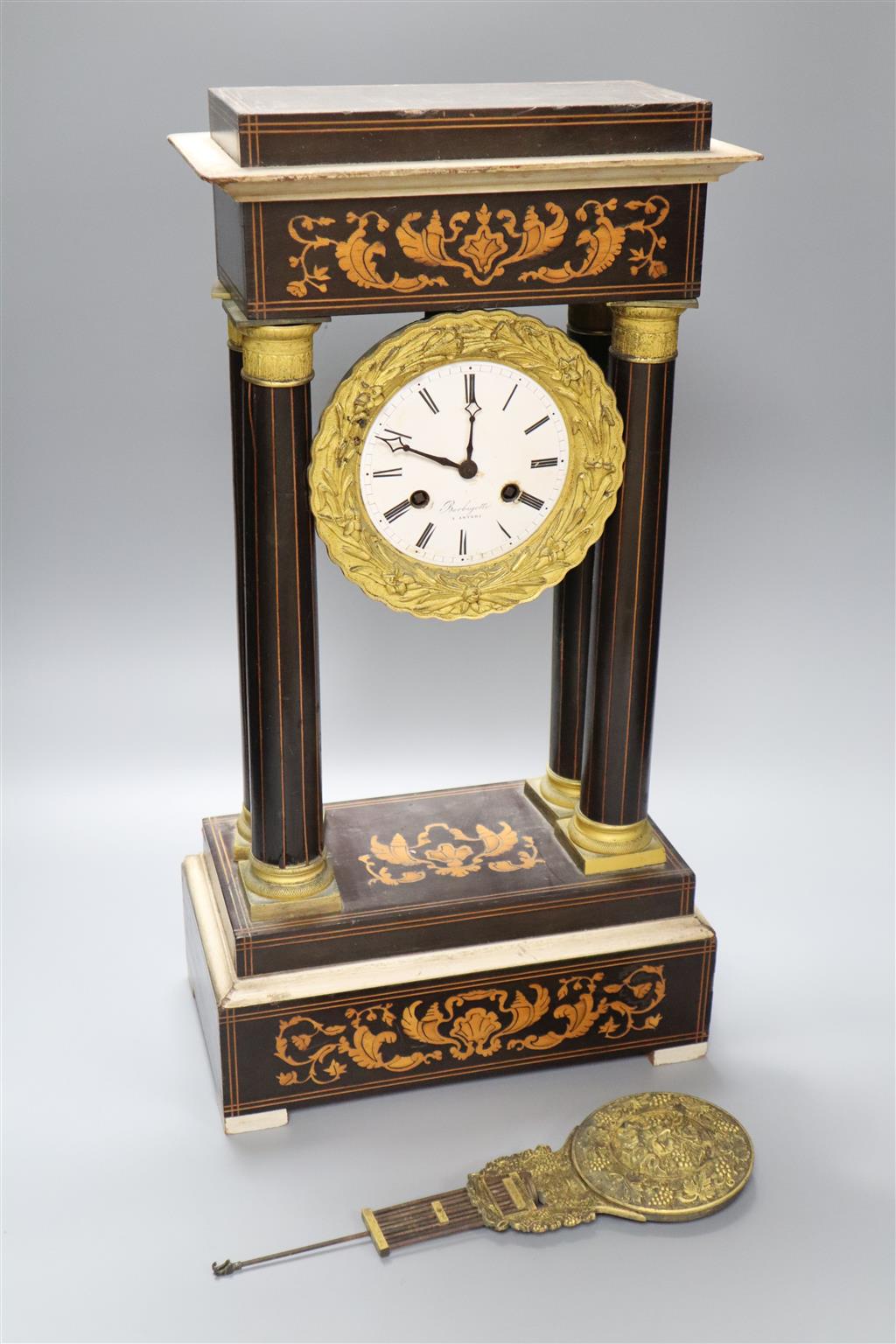 A 19th century inlaid French Portico mantel clock, with cast bacchus pendulum, 49cm